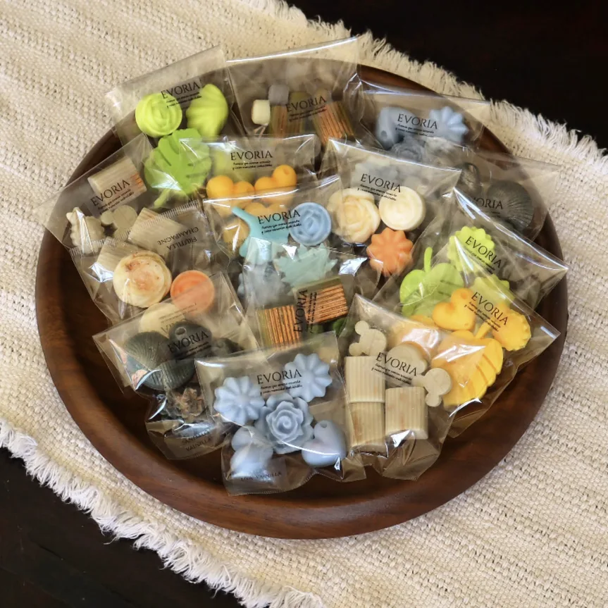 Bolsitas de wax melts Evoria de distintos colores y formas en bandeja de madera